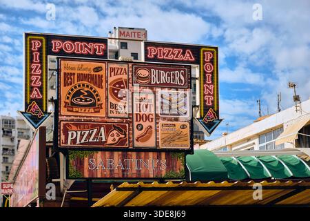 Benalmadena, Spanien - 24. Dezember 2025: Ein lebhaftes Pizza Point Restaurant in Benalmadena Costa del Sol Spanien zeigt Werbung für Burger ho Stockfoto