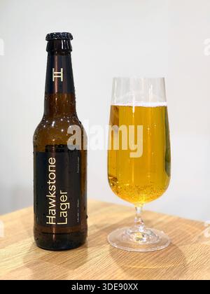 Goldenes Bier in einem Glas und eine Flasche Hawkstone Lager auf einer Küchenarbeitsfläche Stockfoto
