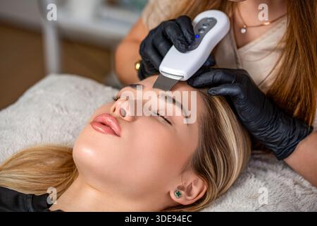 Hautpflege. Ultraschall-Hautreinigungsverfahren. Kosmetik. Schönheitsbehandlungen. Schönheitsarzt-Ultraschallwäscher, der Ultraschallverfahren durchführt Stockfoto