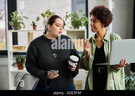 Zwei unterschiedliche Geschäftsfrauen führen während ihrer Zusammenarbeit produktive Diskussionen. Stockfoto