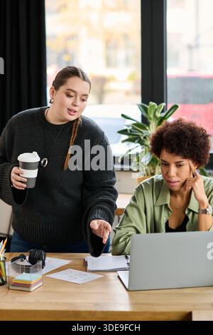 Zwei weibliche Führungskräfte führen in ihrem modernen Büro produktive Gespräche und tauschen ihre Erkenntnisse aus. Stockfoto