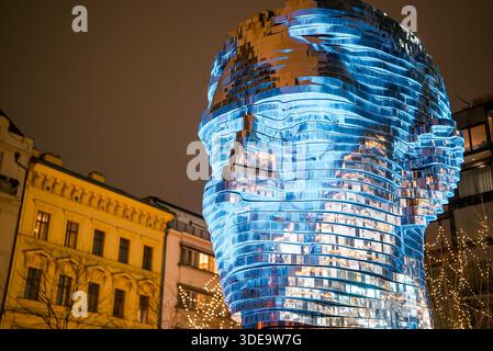 Prag, Tschechien - 20. Dezember 2025. Nachtansicht der rotierenden Franz Kafka Head Skulptur. Mit bunten Lichtern beleuchtet. Auffällige kinetische Kunst Stockfoto