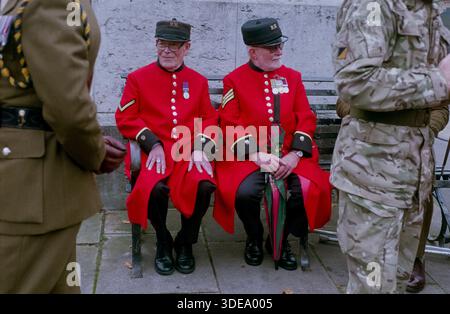 Zwei Chelsea-Rentner sitzen am Grantham-Kriegsdenkmal 2014. Chelsea Pensioners sind ikonische Veteranen der Armee, die im Royal Hospital Chelsea in London leben. 1682 von König Karl II. Für diejenigen gegründet, die durch Alter oder Krieg gebrochen wurden, beherbergt das Krankenhaus derzeit etwa 300 Männer und Frauen. Sie sind weltbekannt für ihre zeremoniellen Scharlachmäntel und Tricornehüte, die sie für offizielle Veranstaltungen wie die Chelsea Flower Show tragen. Um beitreten zu können, müssen Veteranen über 65 Jahre alt sein, unabhängig und frei von Angehörigen sein und ihre Armeeresrente im Austausch für Pflege abgeben. Stockfoto