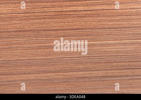 Nahaufnahme einer braunen, matten Oberfläche, die komplexe lineare Texturen und warme Töne hervorhebt, perfekt für Design- und künstlerische Anwendungen Stockfoto