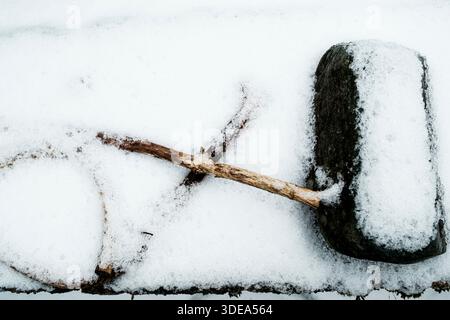Steine und Zweige, die mit Schnee bedeckt sind, schaffen ein abstraktes Muster Stockfoto