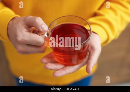 Mann mit einer Tasse heißem Tee drinnen, Nahaufnahme Stockfoto