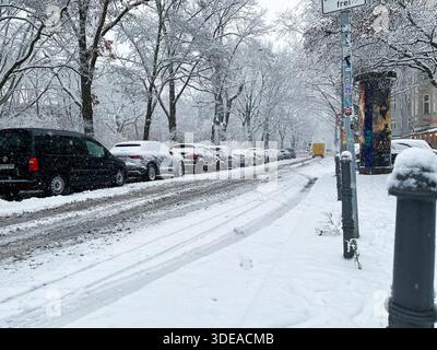 Grimmstraße mit Parkplätzen und Bäumen im Schnee in Berlin Kreuzberg. Rutschige Straße. Stockfoto