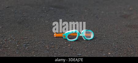 Schwimmbrille auf schwarzem vulkanischem Sand Teneriffa Strand Stockfoto