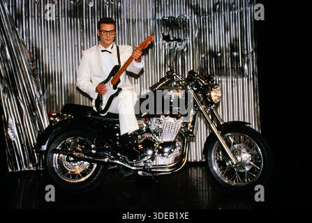 Schauspieler und Musiker Fabian Harloff im Musical Buddy, es handelt vom Rock 'n' Roll Musiker Buddy Holly, hier sieht man Hauptdarsteller Fabian Harloff mit Fender Stratocaster Gitarre auf einem Triumpf Motorrad, auf der Bühne des Musical-Theaters in Hamburg, 1994. Stockfoto