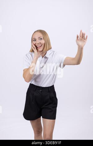 Fröhliche Frau, die ihre Hand in Gruß winkt. Stockfoto