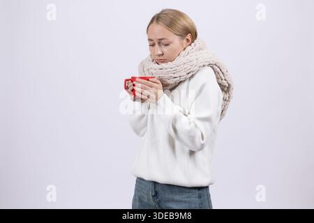 Kalte Frau in einen Schal gewickelt mit einer roten Tasse. Stockfoto