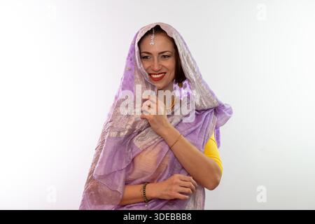 Eine Frau mittleren Alters in einem indischen Sari mit einem überdachten Lächeln Stockfoto