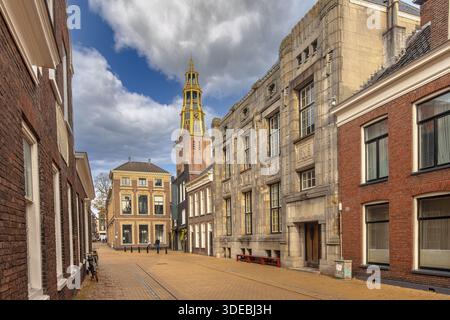 Stadtbild straßenblick von Groningen in Munnekeholm. Mit Straße, alten Häusern und mittelalterlicher AA-Kirche im Hintergrund. Städtische Landschaft Europas. Ne Stockfoto