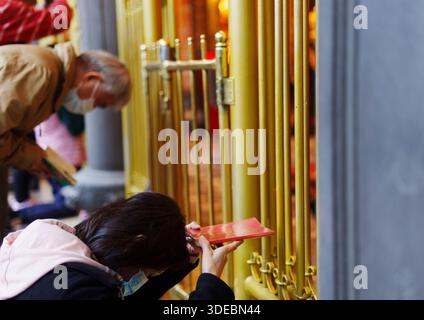 26. November 2024, Taiwan, Taipeh: Gläubige stehen mit gefalteten Händen im Tempel. Der Mengjia Longshan-Tempel ist Taipeis ältester Tempel und befindet sich im Viertel Manka. Die Bewohner der Nachbarschaft nutzen den Tempel als Gottesdienst, aber er ist auch ein gesellschaftlicher Treffpunkt. Foto: Andreas Arnold/dpa Stockfoto