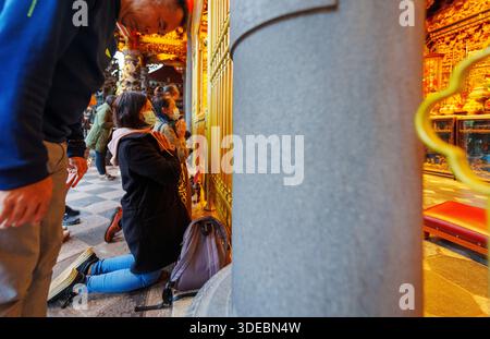 26. November 2024, Taiwan, Taipeh: Gläubige knien im Tempel. Der Mengjia Longshan-Tempel ist Taipeis ältester Tempel und befindet sich im Viertel Manka. Die Bewohner der Nachbarschaft nutzen den Tempel als Gottesdienst, aber er ist auch ein gesellschaftlicher Treffpunkt. Foto: Andreas Arnold/dpa Stockfoto