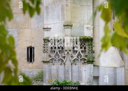 Gotische Steinarchitektur mit geschnitztem Tracery und Moos an der Außenseite der St. Leonard Kirche in Honfleur, Frankreich. Kunstvolle mittelalterliche Steinmetzarbeiten. Stockfoto