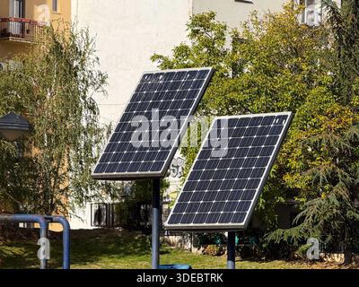 Solarpaneele im Stadtpark installiert. Erneuerbare Energien, nachhaltige Technologie und umweltfreundliche Infrastruktur im öffentlichen Raum. Stockfoto