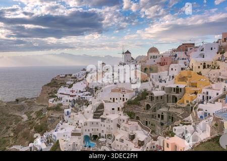 Panoramablick auf weiß getünchte Häuser und Windmühlen im Dorf Oia auf der Insel Santorin, Griechenland, mit Blick auf die Ägäis. Stockfoto