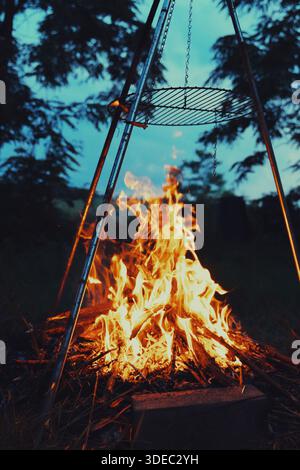Reisen rumänien transilvania targu mures Lagerfeuer brennt hell unter einem tragbaren Grill und erzeugt Wärme in einem Wald im Freien Stockfoto