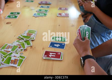 Reisen rumänien transilvania targu mures Hände halten Skip-bo Karten während eines Spiels auf einer hölzernen Tischplatte und schaffen so eine wettbewerbsfähige Atmosphäre Stockfoto