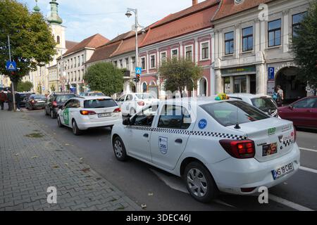 Reise rumänien transilvania targu mures Taxis und Autos fahren durch die geschäftige Straße in targu mures, rumänien mit historischen Gebäuden Stockfoto