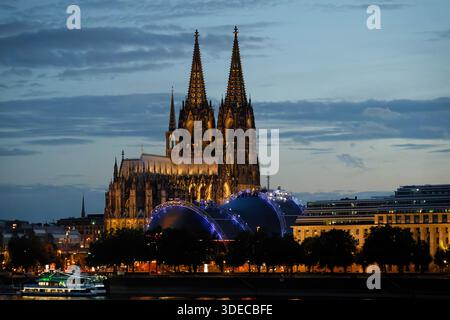 Nachtansicht auf den Kölner Dom, den blau beleuchteten Musical Dome und das EASA-Gebäude am Rheinufer in Deutschland bei Dämmerung Stockfoto