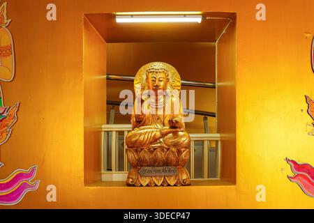 Goldene sitzende Buddha-Statue in einer speziellen Spendernische im Wat Tha Ton, einem modernen buddhistischen Tempel auf einem Hügel im Bezirk Mae Ai, Provinz Chiang Mai, Norden Stockfoto