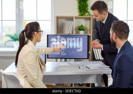 Kollegen diskutieren Analyse- und Finanzdaten auf dem Bildschirm während des Strategiegesprächs Stockfoto