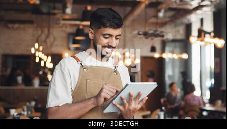 Restaurant, glücklicher Mann und Kellner lesen mit Tablet, Tischverwaltung und Online-Service-Plattform. Überprüfen Sie die Reservierung, die Aktualisierung des Browsermenüs und Stockfoto