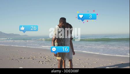 Küssendes Paar in weißer Sonnenbrille und bedruckten Hemdshorts am Sandstrand, Bubbles 26 oder 16 Stockfoto