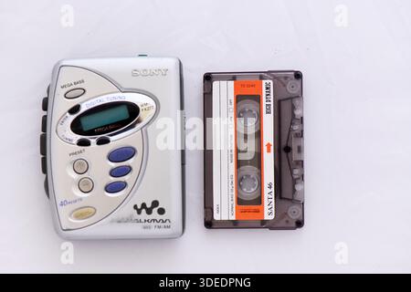Tragbarer Sony WALKMAN ® -Kassettenspieler in Vintage-Silber und ein High Dynamic-Audiokassette Santa 46. Analoge Musiktechnologie im Retro-Stil der 1990er Jahre isoliert auf einem weißen B Stockfoto