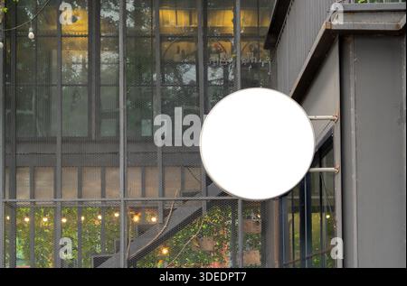Leeres, runder Schilder für das Branding in Geschäften oder Cafés und die Werbung im Außenbereich. Kopierbereich. Stockfoto