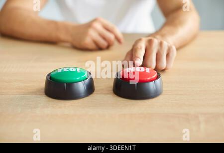 Nahaufnahme eines Mannes, der am Holzschreibtisch sitzt und die Tasten „Ja“ und „Nein“ hat eine Wahl getroffen Stockfoto