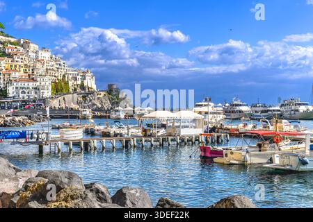 Die atemberaubende Stadt Amalfi. Farbenfrohe Hütten säumen den Hafen mit steilen Stufen hinauf zu hohen Aussichten. Pastellhäuser sind in Hülle und Fülle vorhanden und machen das Reiseziel zu einem Wahrzeichen. Stockfoto