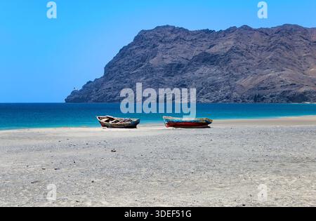 Fischerboote am Strand, Praia de Sao Pedro, Insel Sao Vicente, Kap Verde, Cabo Verde, Afrika. Farol de Dona Amelia im Hintergrund. Stockfoto