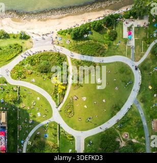 Blick aus der Vogelperspektive auf üppige Grünflächen mit vielen Menschen, die einen sonnigen Tag im Marsha P Johnson Park, Brooklyn, New York, USA, genießen. Stockfoto