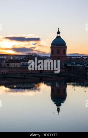 Airbus A330-743L Beluga XL fliegt auf der Höhe der Grabkuppel von La bei Sonnenuntergang in Toulouse Stockfoto