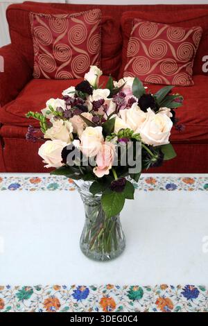 Blumenstrauß aus weißen und rosa Rosen in einer geschliffenen Kristallvase auf einem Marmortisch Stockfoto