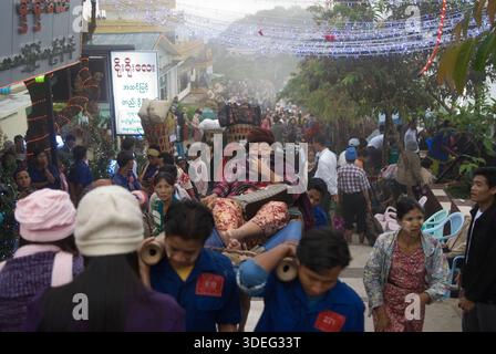 Träger tragen eine ältere Frau den Berg hinauf zum Golden Rock Tazaungdaing Festival auf einer traditionellen Bambustrage, die manchmal als hölzernes Streichbett oder einfach nur als Trage bezeichnet wird, Myanmars Festival of Lights. Ein buddhistisches fest am Ende der Regenzeit, wo der heilige Goldene Felsen zu einem wichtigen Wallfahrtsort wird. Kyaiktiyo, Mons State, Myanmar 9. November 2011 2010, HOMER SYKES Stockfoto