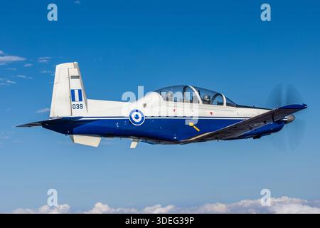 Dieses Nahaufnahme-Luftbild zeigt einen Hellenic Air Force Raytheon T-6A/NTA Texan II auf der Athens Flying Week 2025. Die Registrierung 039, Seriennummer PG-39, ist 120 Air Training Wing zugeordnet. Das Foto betont den Piloten im Tandem-Cockpit unter dem Vordach. Der T-6A ist ein einmotoriger Turboprop-Trainer mit einem Pratt & Whitney Canada PT6A-68-Motor mit einem fünfblättrigen Propeller, der häufig für Grundflugtraining, Kunstflugübungen und Formationsübungen verwendet wird. Stockfoto