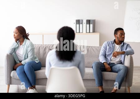 Rückansicht einer Psychologin, die dem jungen schwarzen Paar im Büro eine Therapiesitzung gab und ihnen bei Konflikten half Stockfoto