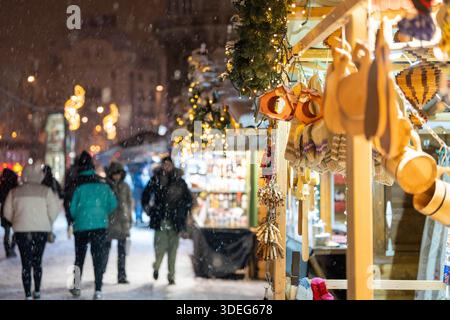 Budapest, Ungarn - 6. Januar 2026: Eine warme Vintage-Straßenlaterne leuchtet, wenn schwerer Schnee über geschwungene Straßenbahnschienen in Budapest fällt, was ein gemütliches und angenehmes Ambiente schafft Stockfoto