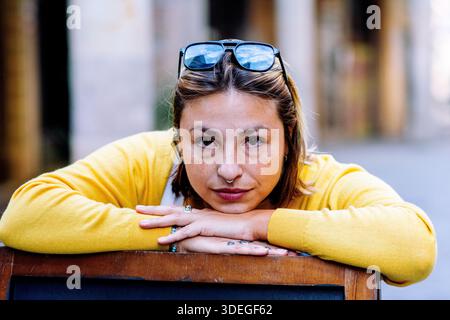 Junge Frau mit Sonnenbrille auf Holzoberfläche Stockfoto