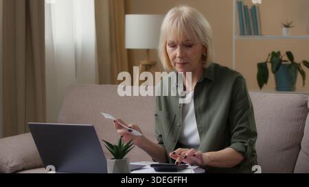 Kaukasische alte Frau, die das persönliche Familienbudget verwaltet, Geld zählt mit Quittungsscheck Ausgaben mit Laptop-Rechner, die Finanzen überprüfen Stockfoto