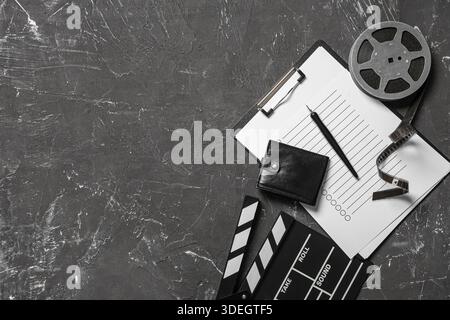 Brieftasche mit Filmklatsche, Filmrolle und Klemmbrett auf dunklem Hintergrund Stockfoto