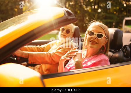 Glückliches älteres Paar, das die Fahrt im Cabrio an sonnigen Tagen genießt Stockfoto