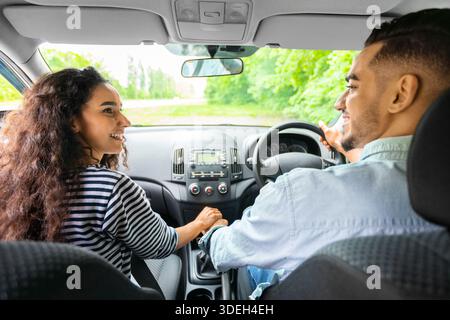 Liebevolles Paar, das die Hände hält, während es im Auto sitzt, Rückansicht Stockfoto
