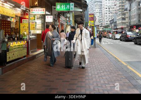 Die Leute laufen auf einer geschäftigen Straße in Hongkong, in der Nähe des 7-Eleven Stockfoto