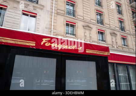 Paris, Frankreich - 7. Januar 2026: Die rote Markise mit dem Pariser Logo von Fouquet ist an einem Wintertag vor einem historischen Steingebäude mit mehreren Fenstern und roten Fensterakzenten zu sehen. Stockfoto