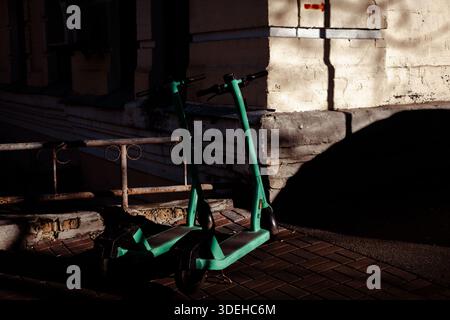 KIEW, Ukraine 13. Dezember 2025 urbane grüne Mobilität. Ein gemeinsamer Elektroroller, der auf einem Bürgersteig der Stadt geparkt ist, symbolisiert nachhaltige Verkehrsmittel Stockfoto